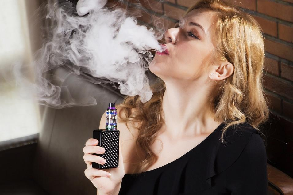 a woman uses disposable vape