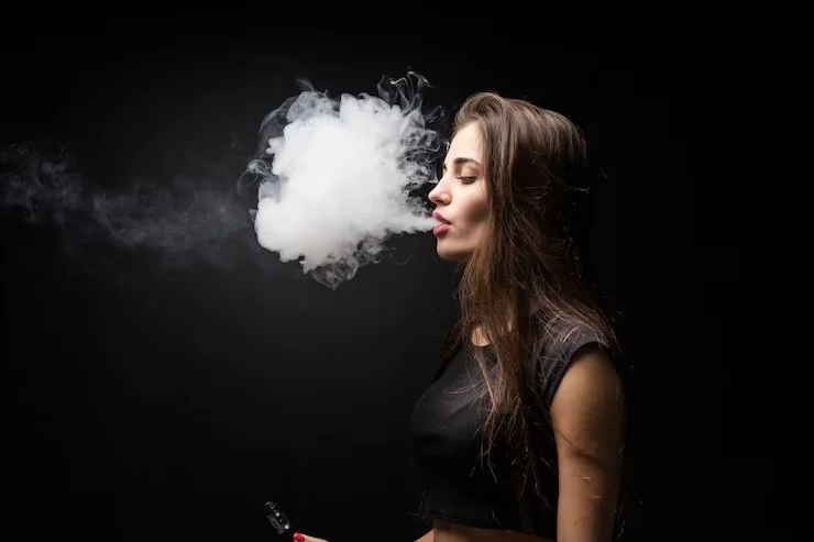 1 sexy-girl-black-dress-smoking-electronic-cigarette-dark-wall_231208-3633